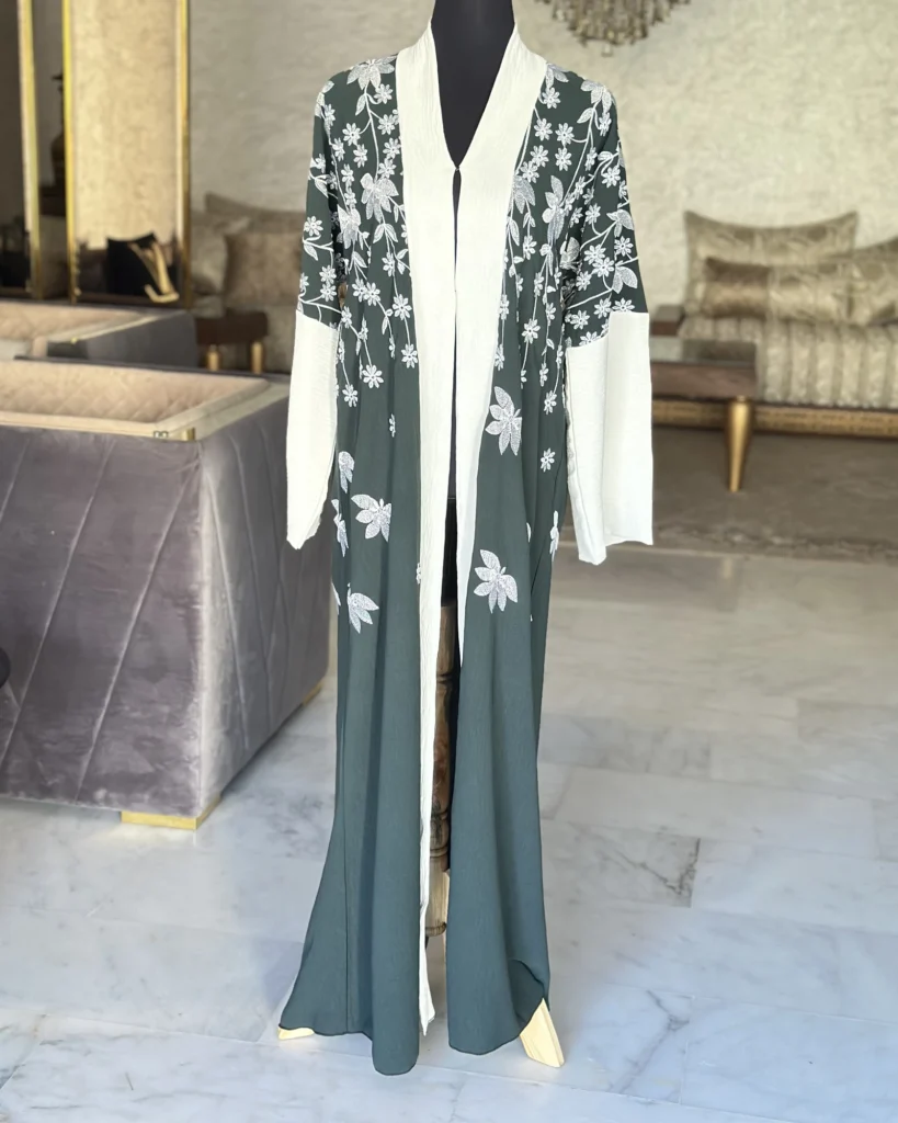 Abaya brodée vert bouteille et ivoire, fleurs blanches, style Dubaï – Yasmin al-Sham, Diwan Reem